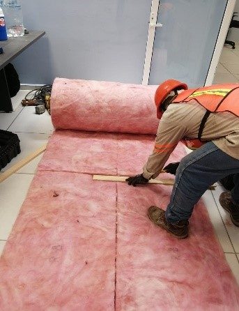 Técnico JALMOR cortando lana de vidrio para aislamiento acústico nave industrial Tampico