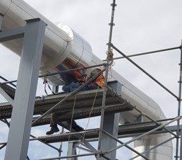 Técnico JALMOR Industrial instalando tubería industrial en altura con arnés planta Tampico
